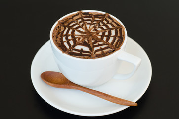 a cup of latte art on black background