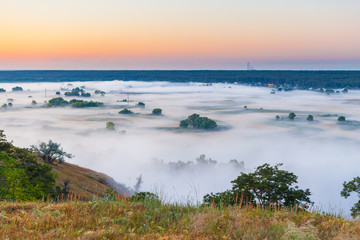 Fototapeta na wymiar Misty dawn over Valley and the forest