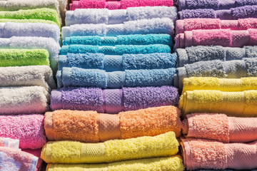 Colorful bath towels stacked on rows in market