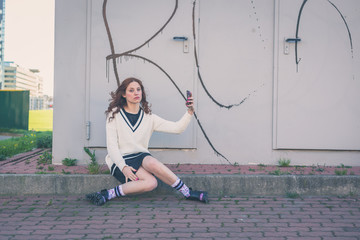 Beautiful girl taking a selfie in an urban context