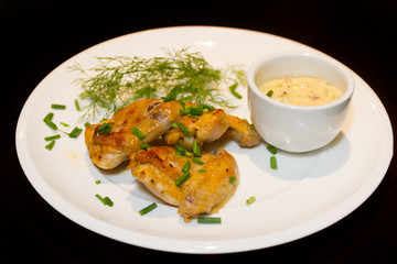 fried chicken wings served with source on white plate isoalted o