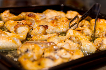 roasted chicken wings on wooden cutting board isolated over blac