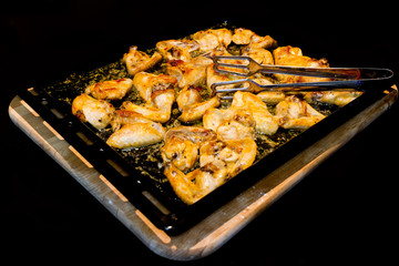 roasted chicken wings on wooden cutting board isolated over blac