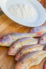 fresh fish on wooden cutting board ready for cooking