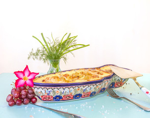 fish under chees source isolated over white with grapes, flower