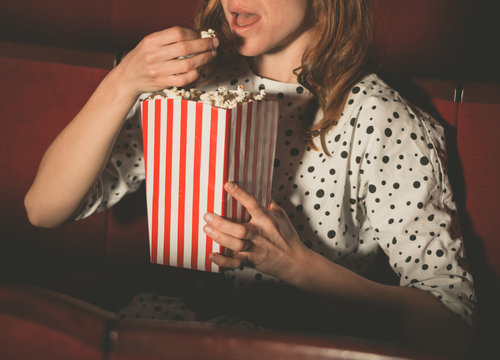 Woman eating popcorn and watching movie