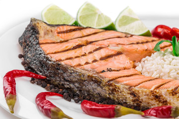 Grilled salmon steak with vegetables on plate.