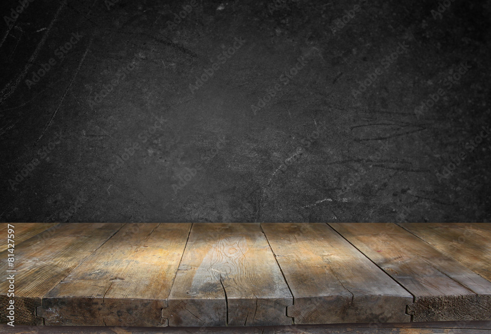 Wall mural grunge vintage wooden board table in front of black textured bac