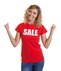 Jubelnde blonde Frau im Sale-Shirt