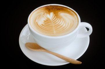 a cup of latte art on black background