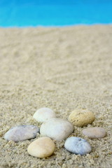 Fototapeta na wymiar soleil en forme galets sur la plage