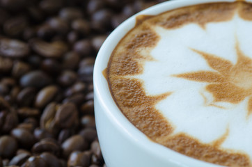 a cup of latte art on coffee bean background