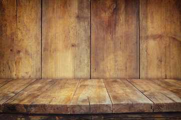 Grunge vintage wooden board table in front of old wooden backgro