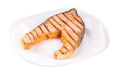 Crispy grilled salmon steak on plate.