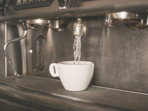 Coffee machine and a small white cup
