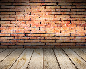 Old interior with red brick wall and wooden floor.