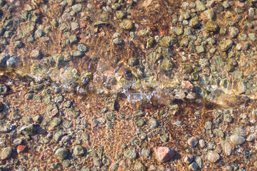 Lake pebble closeup. Little wave