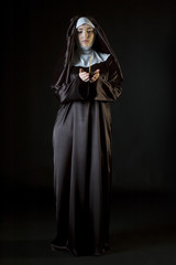 Naklejka premium Nun holding candle