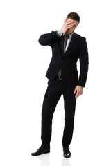 Worried businessman touching his forehead.