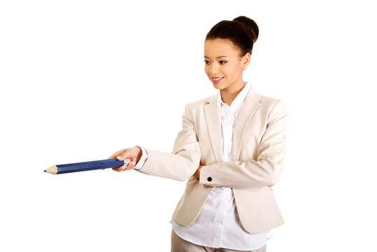 Businesswoman pointing down with big pencil.