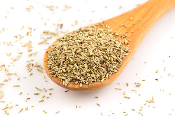 Dried rosemary leaves in wooden spoon
