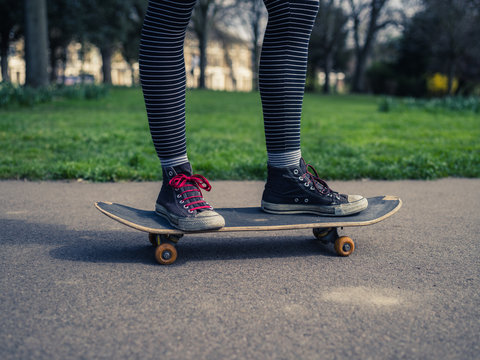Legs of person skateboarding in the park