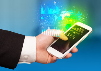 Hand holding smartphone with business diagrams