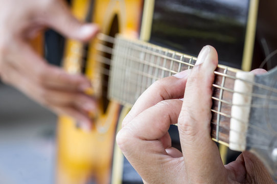 Hand playing acoustic guitar,