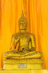Gold buddha statue with the yellow background