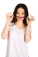 Obraz na płótnie Canvas Teen woman putting hair like moustache.