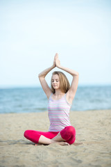 Fototapeta na wymiar Young lady practicing yoga. Workout near ocean sea coast.