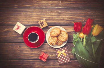 Cup of coffee with cookies and gifts