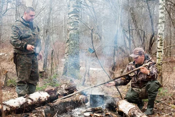 Crédence de cuisine en verre imprimé Chasser deux chasseurs au feu de camp