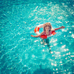 Happy child playing in swimming pool
