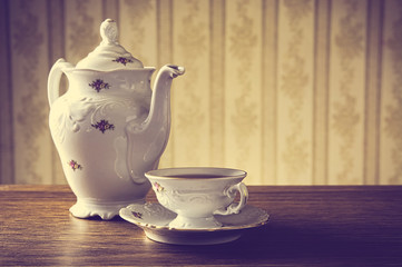 ld-fashioned vintage jug with tea with wallpaper background
