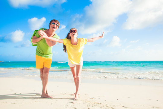 picture of happy couple in sunglasses having fun at the beach