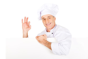 Chef in white uniform holding empty banner