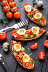 Bruschetta with tomato, avocado and quail egg