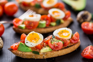 Bruschetta with tomato, avocado and quail egg