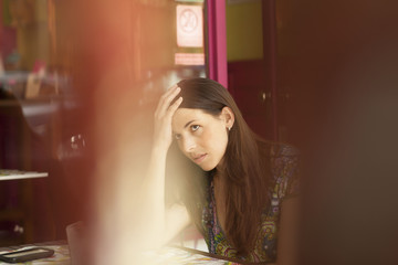 Young latin woman at street bar worried