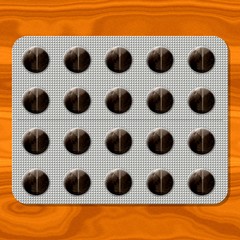 Brown round pills in blister on wooden texture