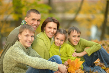 Family relaxing in autumn park