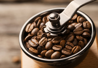 Roasted coffee beans are ground in a coffee grinder.