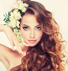 Spring freshness. Girl with delicate pastel flowers in hair