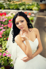 Adorable young caucasian bride in garden, sunny summer day