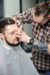 Barber shaves a client with razor