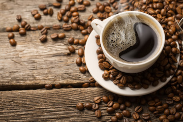 Coffee cup and saucer on a wooden table. Dark background.
