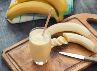 Papier Peint photo Milk-shake Fresh made Banana smoothie on wooden background