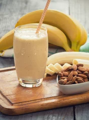 Papier Peint photo Lavable Milk-shake Fresh made Banana smoothie on wooden background