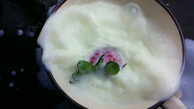 Strawberrie falling into milk. Splash